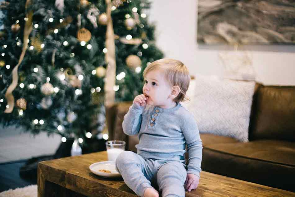 Los niños en la mesa de Navidad bien controlados por los mayores. Niño en Navidad