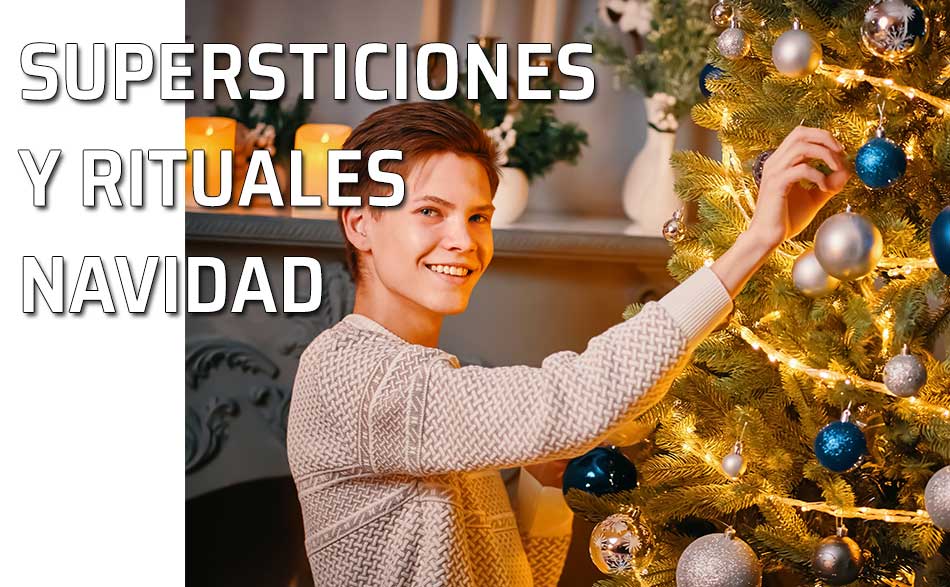 Un chico coloca unos adornos en el árbol de Navidad