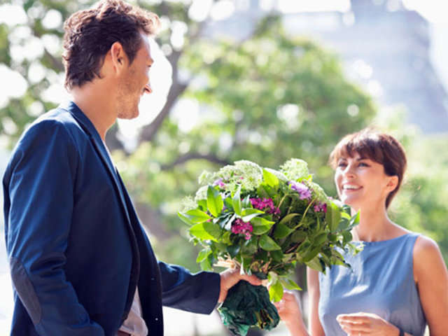 Hombre regala flores a una mujer