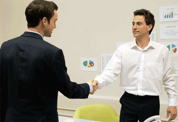 Dos hombres de negocios se saludan dándose la mano.