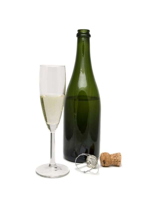 Botella de cava descorchada y copa.