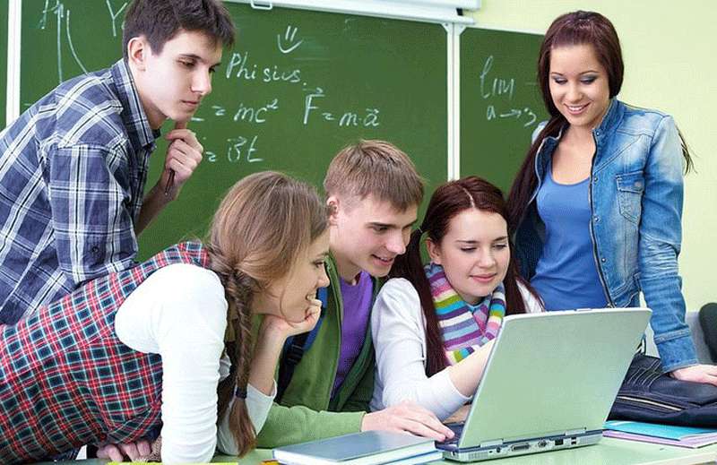 Jóvenes estudiantes delante de un ordenador.