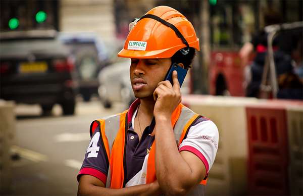 Obrero de la construcción habla por teléfono.