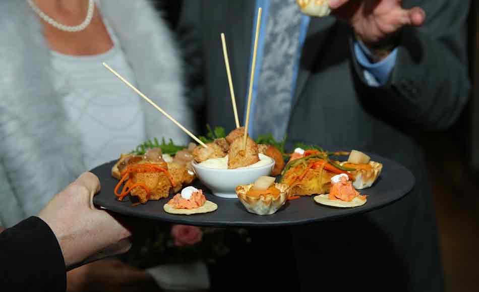 La comida de empresa de Navidad. Moderación al comer y al beber. Tomando un canapé