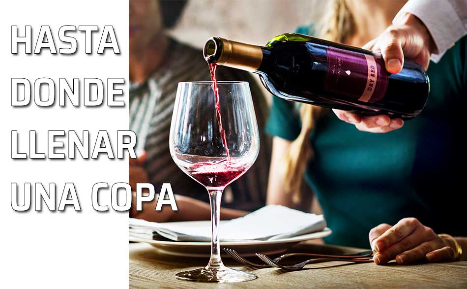 Un camarero sirve un poco de vino en una copa