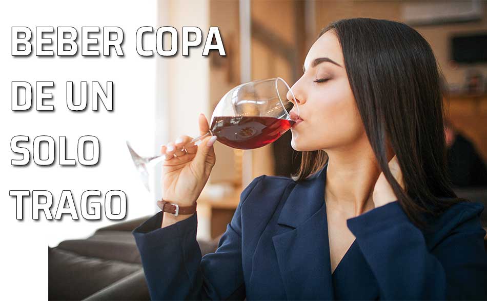 Una mujer tomar un sorbo de una copa de vino