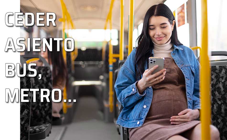 Una mujer embarazada mira su móvil sentada en el autobús