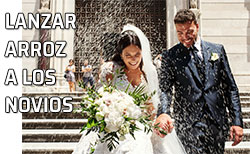 Una pareja de recién casados sale de la iglesia entre una lluvia de arroz
