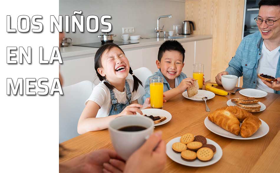 Dos niños sentados a la mesa con su familia