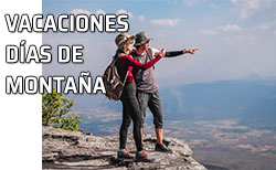 Pareja divisa el paisaje desde lo alto de una montaña