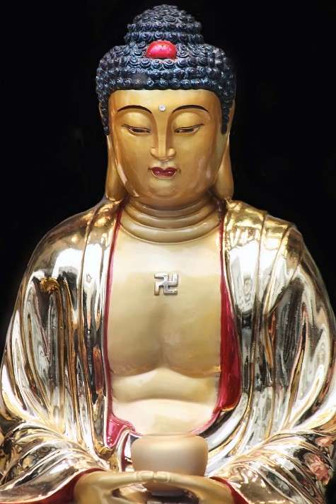 Imagen de un Buda de oro con una sauvástica en el pecho