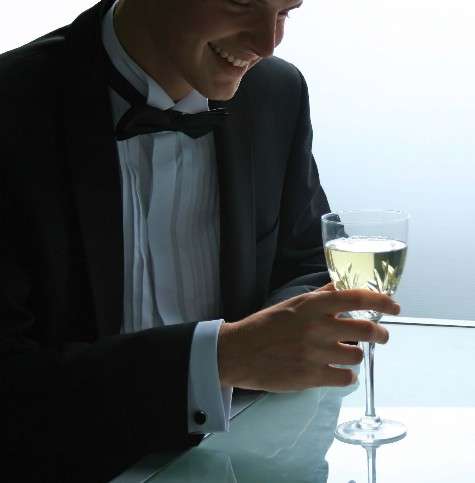 Caballero de smoking tomando una copa.