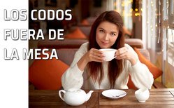 Una mujer apoya los codos mientras toma una taza de té