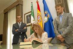 Susana Díaz firma en un libro de honor.