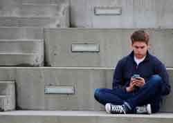 Conocer mejor cómo se expresan los adolescentes, Adolescente consulta su celular-móvil