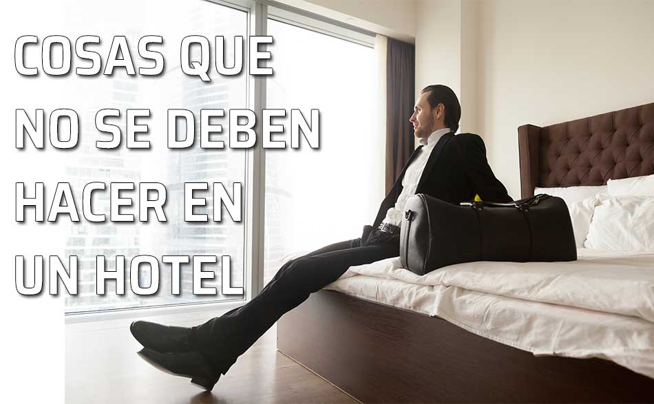 Un hombre se relaja sentado en la cama de la habitación de su hotel