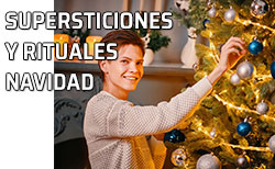 Un chico coloca unos adornos en el árbol de Navidad