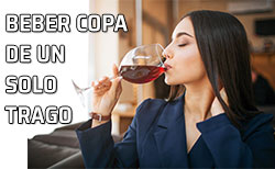 Una mujer tomar un sorbo de una copa de vino